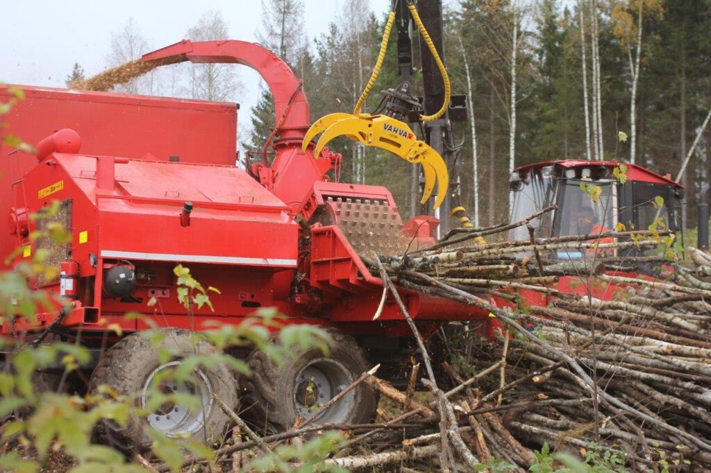 Kuvassa on Vahva C21 E4 kahmari lastaamassa puuta hakkuriin